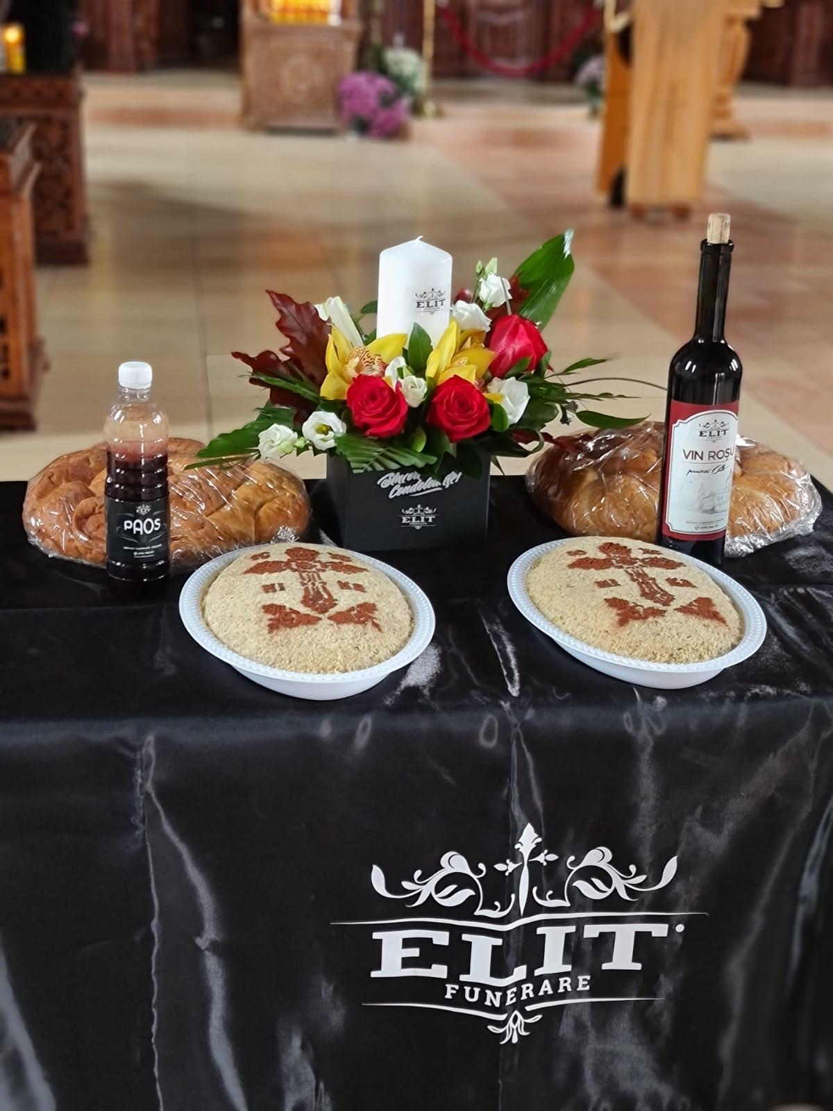 Masă de pomenire Elit Funerare — colivă, colaci, vin și aranjament floral în biserică