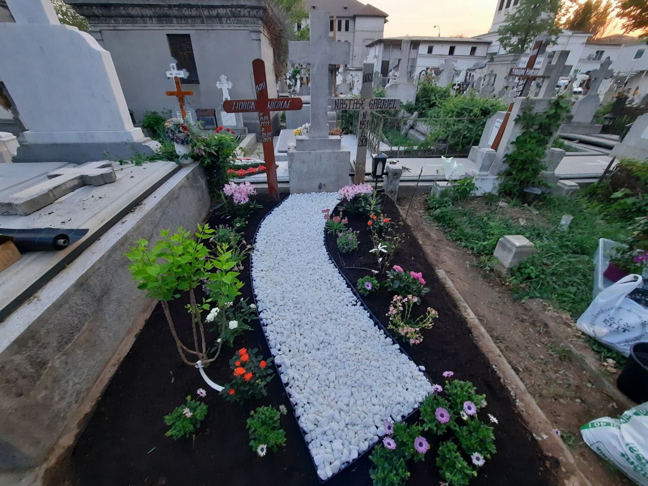 Mormânt amenajat cu pietricele albe și flori